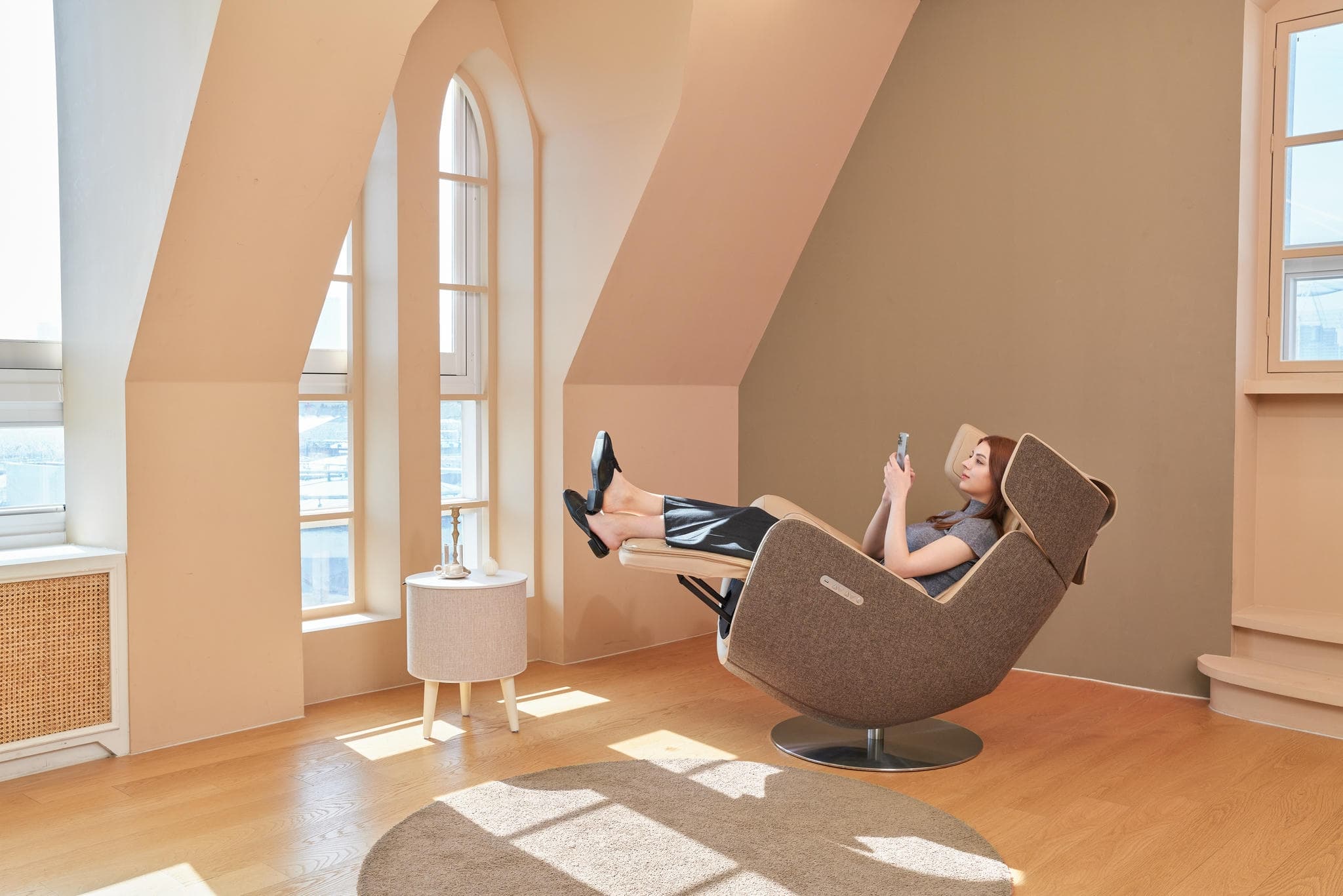 Kobieta odpoczywająca w fotelu masującym Nouhaus Orbit w jasnym wnętrzu